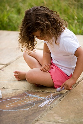 DESIGNER_CLARE_MATTHEWS_CHALK_GAME__GIRL_DRAWING_WITH_CHALK_ON_PATIO