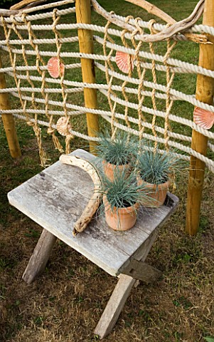 DESIGNER_CLARE_MATTHEWS_ROPE_SCREEN_HIDEAWAY__ROPE_SCREEN_WITH_WOODEN_TABLE__TERRACOTTA_CONTAINERS_A