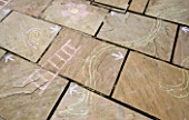 DESIGNER: CLARE MATTHEWS: SNAKES AND LADDERS. CHALK DRAWING OF SNAKES AND LADDERS ON PATIO