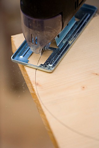 DESIGNER_CLARE_MATTHEWS_BENCH_AND_TABLE_PROJECT__CUTTING_OUT_CURVE_MARKED_OUT_ON_WOOD_WITH_PLATE
