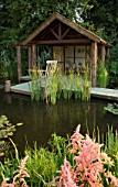 HAMPTON COURT FLOWER SHOW 2006: DESIGNER - PETER SIMS. A JETTY ACROSS A POND  POOL AND WOODEN SUMMERHOUSE  BOATHOUSE
