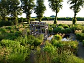 BURY COURT  HAMPSHIRE: FRONT GARDEN DESIGNED BY CHRISTOPHER BRADLEY-HOLE. LARGE SQUARE FORMAL POOL  WOODEN COVERED SEATING AREA AND PERENNIALS AND GRASSES