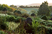 VEDDW HOUSE GARDEN  GWENT  WALES: DESIGNERS ANNE WAREHAM AND CHARLES HAWES - VIEW ACROSS THE GRASSES PARTERRE TO THE COUNTRYSIDE BEYOND