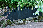 VEDDW HOUSE GARDEN  GWENT  WALES: DESIGNERS ANNE WAREHAM AND CHARLES HAWES - UNUSUAL BLACK FENCE WITH CUT OUT TOP