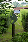 VEDDW HOUSE GARDEN  GWENT  WALES: DESIGNERS ANNE WAREHAM AND CHARLES HAWES - VIEW TO THE HOUSE FROM THE END OF AN AVENUE WITH A CUT OUT OF A WOODEN DOVE ON A WOODEN POST