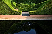 VEDDW HOUSE GARDEN  GWENT  WALES: DESIGNERS ANNE WAREHAM AND CHARLES HAWES - THE REFLECTING POOL WITH GRAVEL AND WAVE HEDGING
