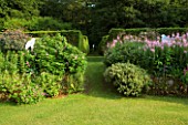 VEDDW HOUSE GARDEN  GWENT  WALES: DESIGNERS ANNE WAREHAM AND CHARLES HAWES - THE CRESCENT BORDER WITH BUZZARD CUT OUTS  EPILOBIUM ANGUSTIFOLIUM AND VIEW ALONG AVENUE