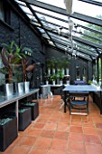 VEDDW HOUSE GARDEN  GWENT  WALES: DESIGNERS ANNE WAREHAM AND CHARLES HAWES - THE CONSERVATORY PAINTED BLACK