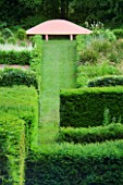 VEDDW HOUSE GARDEN  GWENT  WALES: DESIGNERS ANNE WAREHAM AND CHARLES HAWES - VIEW ALONG A GRASS PATH UP A HILL TO A PINK SEAT/ BENCH IN THE GRASSES PARTERRE