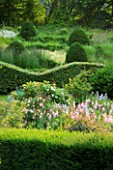 VEDDW HOUSE GARDEN  GWENT  WALES: DESIGNERS ANNE WAREHAM AND CHARLES HAWES - VIEW ACROSS GRASSES PARTERRE AND WAVE HEDGING