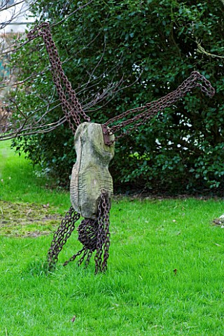 WOODPECKERS__WARWICKSHIRE__WINTER_SCULPTURE_OF_MAN_DOING_A_HANDSTAND_IN_LAWN
