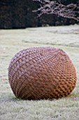 WOODPECKERS  WARWICKSHIRE  WINTER: WOVEN WILLOW  BALL SCULPTURE ON FROSTED LAWN