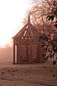 WOODPECKERS  WARWICKSHIRE  WINTER: EARLY MORNING VIEW OF FROSTED LAWN WITH WOODEN SUMMERHOUSE