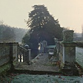 STONE BALUSTRADED STEPS BY HAROLD PETO LEAD DOWN TO A JETTY ON THE AVON AND THE WATER MEADOWS BEYOND. HEALE HOUSE  WILTS