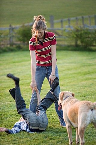 GIRL_AND_BOY_PLAYING_IN_GARDEN_WITH_DOG_WATCHING_ON