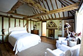 BOONSHILL FARM  EAST SUSSEX. INTERIOR OF BEDROOM WITH WOODEN FLOORBOARDS AND EXPOSED BEAMS. DESIGNER: LISETTE PLEASANCE