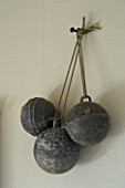 BOONSHILL FARM  EAST SUSSEX. INTERIOR OF BATHROOM WITH OLD FRENCH METAL BALLS HUNG ON WALL AS DECORATION. DESIGNER: LISETTE PLEASANCE