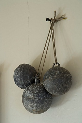 BOONSHILL_FARM__EAST_SUSSEX_INTERIOR_OF_BATHROOM_WITH_OLD_FRENCH_METAL_BALLS_HUNG_ON_WALL_AS_DECORAT