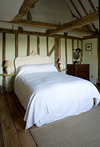 BOONSHILL_FARM__EAST_SUSSEX_INTERIOR_OF_BEDROOM_WITH_WOODEN_FLOORBOARDS__EXPOSED_BEAMS__FRENCH_BEDHE