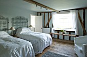 BOONSHILL FARM  EAST SUSSEX. INTERIOR OF GUEST BEDROOM WITH ANTIQUE LACE BEDSPREADS AND METAL GATES AS BEDHEADS. DESIGNER: LISETTE PLEASANCE