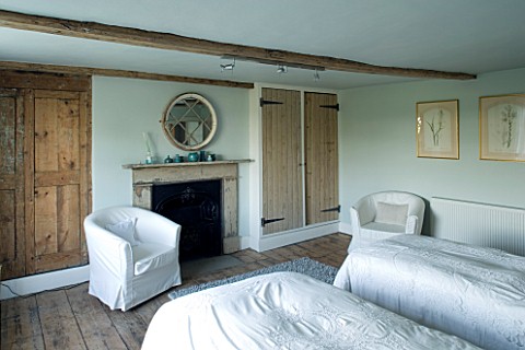 BOONSHILL_FARM__EAST_SUSSEX_INTERIOR_OF_GUEST_BEDROOM_WITH_MIRROR_MADE_FROM_OLD_WINDOW_ABOVE_FIREPLA
