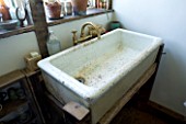 BOONSHILL FARM  EAST SUSSEX. INTERIOR OF PANTRY WITH OLD SINK FOUND IN GARDEN WITH RECLAIMED WOODEN STAND MADE BY MICK SHAW. DESIGNER: LISETTE PLEASANCE