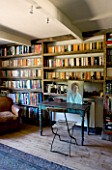 BOONSHILL FARM  EAST SUSSEX. INTERIOR OF STUDY WITH BOOKSHELVES MADE FROM RECLAIMED JOISTS MADE BY MICK SHAW. DESIGNER: LISETTE PLEASANCE