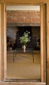 BOONSHILL FARM  EAST SUSSEX. VIEW INTO SITTING ROOM WITH INGLENOOK FIREPLACE AND NATURAL SISAL FLOOR. DESIGNER : LISETTE PLEASANCE