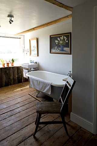 BOONSHILL_FARM__EAST_SUSSEX_INTERIOR_OF_BATHROOM_WITH_OLD_ROLLTOP_CLAWFOOT_BATH__ANTIQUE_CHAIR_FROM_