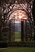 HOLKER HALL  CUMBRIA - SUNSET WITH ORNATE METAL GATE IN THE SUNKEN GARDEN