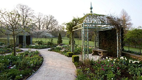 HOLKER_HALL__CUMBRIA_THE_SUNKEN_GARDEN_IN_SPRING_WITH_TULIPS_AND_COVERED_ARBOURS