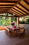 VILLA CHRISTINA   KAMINAKI  CORFU  GREECE: COVERED OUTDOOR PATIO/ TERRACE DINING AREA WITH WOODEN TABLE AND CHAIRS SET FOR ALFRESCO DINING