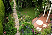 AMELIA HEATH GARDEN: 1 CROSS VILLAS SHROPSHIRE: PATIO: TABLE AND CHAIRS. WOODEN WITH ROSE GOLDFINCH  GLADIOLUS BYZANTINUS  GRAVEL PATH  CLEMATIS ETOILE VIOLETTE  ACONITUM