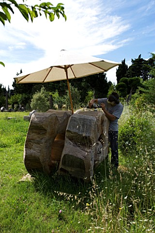 PROVENCE__FRANCE_GARDEN_OF_MARCO_NUCERA_MARCO_NUCERA_WORKING_ON_A_WOODEN_SCULPTURE