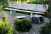 PROVENCE  FRANCE. GARDEN OF MARCO NUCERA. GRAVEL GARDEN WITH HUGE WOODEN SEAT. A PLACE TO SIT