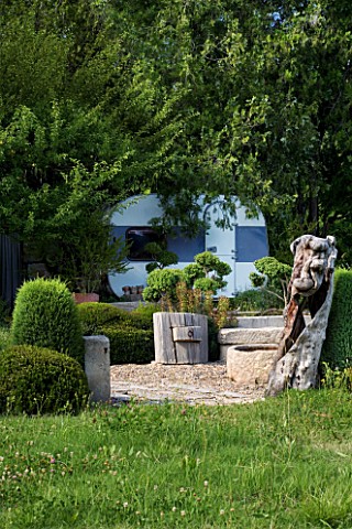PROVENCE__FRANCE_GARDEN_OF_MARCO_NUCERA_VIEW_TO_CARAVAN_WITH_WOODEN_FURNITURE_AND_CLIPPED_FORMS