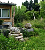 PROVENCE  FRANCE. GARDEN OF MARCO NUCERA. THE HOUSE WITH WOODEN DECK. WOODEN SCULPTURES BY MARCO NUCERA