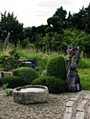 PROVENCE  FRANCE. GARDEN OF MARCO NUCERA. GRAVEL AREA WITH CLIPPED SHAPES AND STONE WATER BOWL