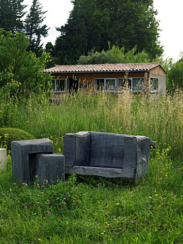 PROVENCE__FRANCE_GARDEN_OF_MARCO_NUCERA_A_PLACE_TO_SIT__CHUNKY_WOODEN_SEAT_IN_LONG_GRASS_WITH_THE_HO