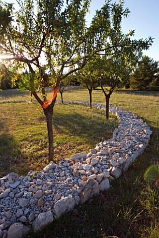 DESIGNER_ALAIN_DAVID_IDOUX__MAS_BENOIT__PROVENCE__FRANCE_VIEW_OF_SPIRAL_OF_FIELD_STONES_AND_ALMOND_T