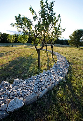 DESIGNER_ALAIN_DAVID_IDOUX__MAS_BENOIT__PROVENCE__FRANCE_VIEW_OF_SPIRAL_OF_FIELD_STONES_AND_ALMOND_T