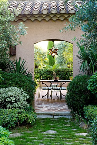 DESIGNER_MICHEL_SEMINI__PROVENCE__FRANCE_VIEW_THROUGH_DOORWAY_TO_MOROCCAN_STYLE_COURTYARD_WITH_TABLE