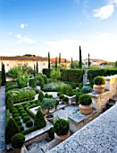 DESIGNER MICHEL SEMINI  PROVENCE  FRANCE. THE FORMAL GARDEN IN THE EVENING WITH BOX EDGED BEDS  BOX BALLS AND CYPRESSES