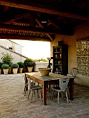 DESIGNER MICHEL SEMINI  PROVENCE  FRANCE. COVERED LOGIA DINING AREA WITHY TABLE  CHAIRS  MOROCCAN STYLE TILES  TELESCOPE