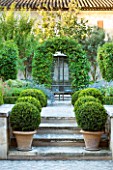 DESIGNER MICHEL SEMINI  PROVENCE  FRANCE. THE FORMAL GARDEN WITH BOX BALLS IN TERRACOTTA CONTAINERS AND METAL AVIARY