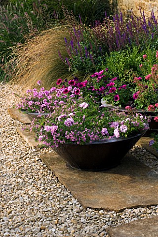 RICKYARD_BARN_GARDEN__NORTHAMPTONSHIRE_STONE_SLABS_ON_THE_PATIO_WITH_GRAVEL__BRONZE_CONTAINERS_PLANT