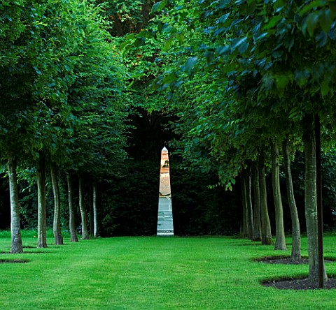 ANGEL_COLLINS_GARDEN_HORNBEAM_AVENUE_WITH_MIRRORED_OBELISK_LIT_BY_DAVID_HARBER_LIT_UP_BY_THE_EVENING
