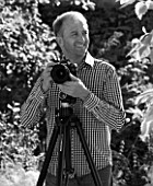 CLIVE NICHOLS IN HIS GARDEN WITH MANFROTTO 058B TRIPOD AND 410 GEARED HEAD - BLACK AND WHITE IMAGE