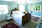 DESIGNER CLARE MATTHEWS  DEVON: BLUE AND WHITE THEMED BEDROOM WITH WOODEN BED AND BLUE HYDRANGEA FLOWERS IN BLUE AND WHITE VASE IN BEDROOM WINDOWSILL