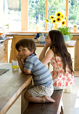 CLARE_MATTHEWS_HOUSE__DEVON_GIRL_AND_BOY_RELAX_AT_THE_KITCHEN_TABLE